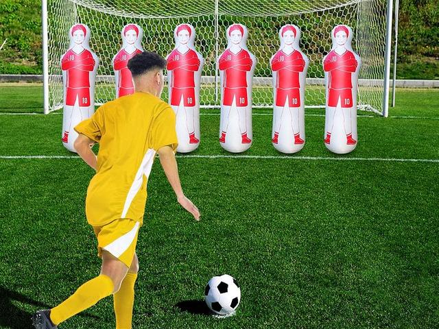 A row of inflatable tackling dummies on a soccer field