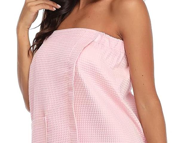 A woman in a pink waffle spa wrap after a shower